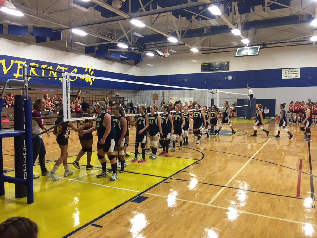 girls shaking hands at the net after playing volleyball